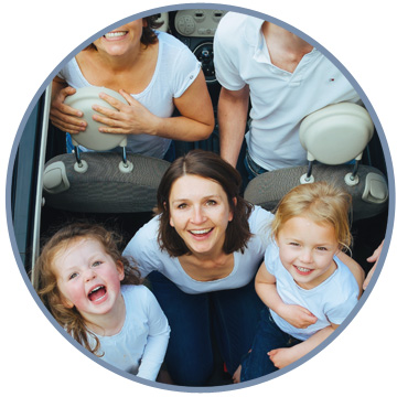 Smiling family sat together in a car